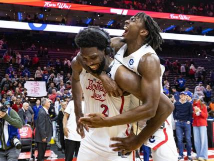 Nov 13, 2022; Philadelphia, Pennsylvania, USA; Philadelphia 76ers guard Tyrese Maxey (0) leaps onto center Joel Embiid (21) after Embiids 59 points in a victory against the Utah Jazz at Wells Fargo Center. Mandatory Credit: Bill Streicher-USA TODAY Sports