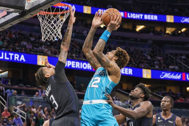 Nov 14, 2022; Orlando, Florida, USA; Charlotte Hornets guard Kelly Oubre Jr. (12) goes to the basket against Orlando Magic forward Chuma Okeke (3) during the second quarter at Amway Center. Mandatory Credit: Mike Watters-USA TODAY Sports