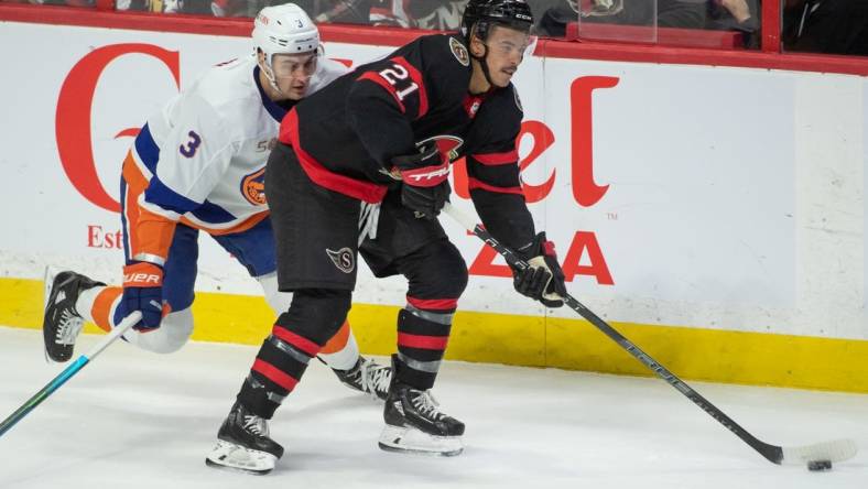 Nov 14, 2022; Ottawa, Ontario, CAN; Ottawa Senators right wing Mathieu Joseph (21) skates with the puck in front of New York Islanders defenseman Adam Pelech (3) in the third period at the Canadian Tire Centre. Mandatory Credit: Marc DesRosiers-USA TODAY Sports