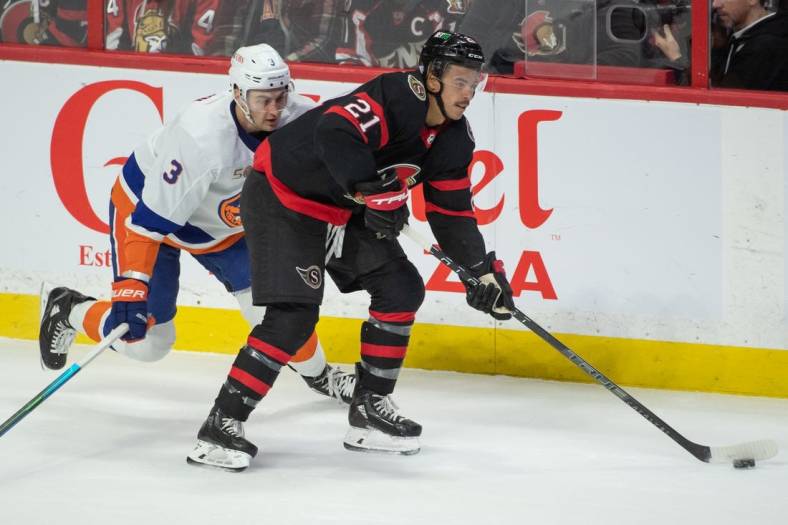 Nov 14, 2022; Ottawa, Ontario, CAN; Ottawa Senators right wing Mathieu Joseph (21) skates with the puck in front of New York Islanders defenseman Adam Pelech (3) in the third period at the Canadian Tire Centre. Mandatory Credit: Marc DesRosiers-USA TODAY Sports