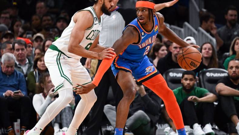 Nov 14, 2022; Boston, Massachusetts, USA; Oklahoma City Thunder guard Shai Gilgeous-Alexander (2) dribbles the ball against Boston Celtics guard Derrick White (9) during the first half at the TD Garden. Mandatory Credit: Brian Fluharty-USA TODAY Sports