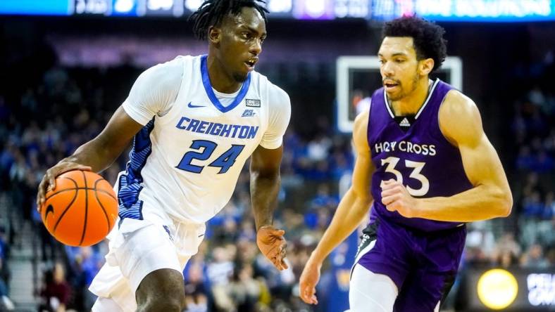 Nov 14, 2022; Omaha, Nebraska, USA; Creighton Bluejays forward Arthur Kaluma (24) drives to the hoop against Holy Cross Crusaders forward Caleb Kenney (33) during the first half at CHI Health Center Omaha. Mandatory Credit: Dylan Widger-USA TODAY Sports