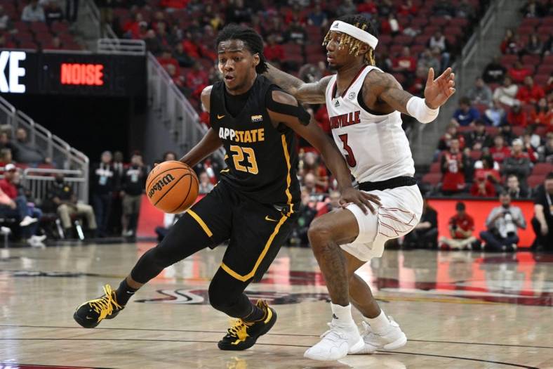 Nov 15, 2022; Louisville, Kentucky, USA;  Appalachian State Mountaineers guard Terence Harcum (23) dribbles against Louisville Cardinals guard El Ellis (3) during the first half at KFC Yum! Center. Mandatory Credit: Jamie Rhodes-USA TODAY Sports