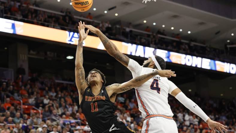 Nov 15, 2022; Auburn, Alabama, USA;  Winthrop Eagles guard Kasen Harrison (11) takes a shot against Auburn Tigers forward Johni Broome (4) during the first half at Neville Arena. Mandatory Credit: John Reed-USA TODAY Sports