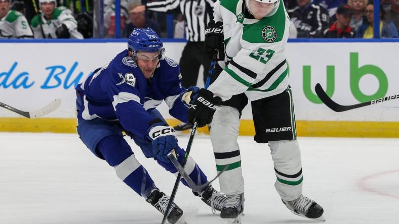 Nov 15, 2022; Tampa, Florida, USA;  Tampa Bay Lightning center Ross Colton (79) and Dallas Stars defenseman Esa Lindell (23) battle for the puck in the first period at Amalie Arena. Mandatory Credit: Nathan Ray Seebeck-USA TODAY Sports