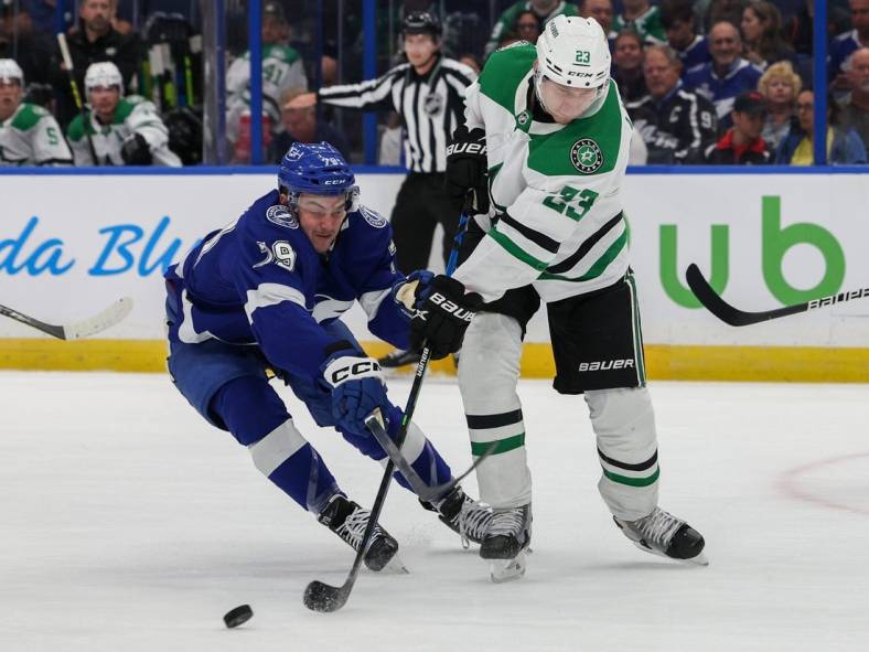 Nov 15, 2022; Tampa, Florida, USA;  Tampa Bay Lightning center Ross Colton (79) and Dallas Stars defenseman Esa Lindell (23) battle for the puck in the first period at Amalie Arena. Mandatory Credit: Nathan Ray Seebeck-USA TODAY Sports