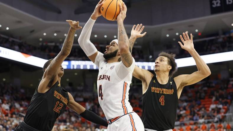 Nov 15, 2022; Auburn, Alabama, USA;  Auburn Tigers forward Johni Broome (4) takes a shot between Winthrop Eagles forwards Cory Hightower (12) and Kelton Talford (4) during the second half against at Neville Arena. Mandatory Credit: John Reed-USA TODAY Sports