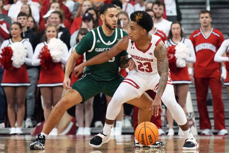 Nov 15, 2022; Madison, Wisconsin, USA; Wisconsin Badgers guard Chucky Hepburn (23) dribbles under coverage by Green Bay Phoenix guard Nate Jenkins (55) during the first half at the Kohl Center. Mandatory Credit: Kayla Wolf-USA TODAY Sports