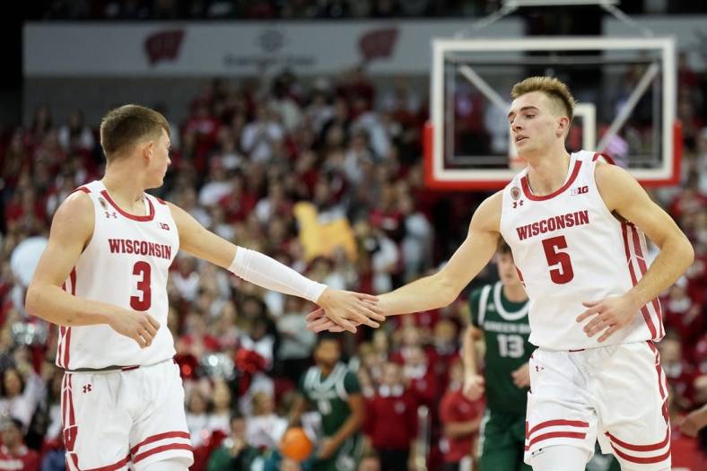 Nov 15, 2022; Madison, Wisconsin, USA; Wisconsin Badgers guard Connor Essegian (3) congratulates Wisconsin Badgers forward Tyler Wahl (5) on scoring against the Green Bay Phoenix during the first half at the Kohl Center. Mandatory Credit: Kayla Wolf-USA TODAY Sports
