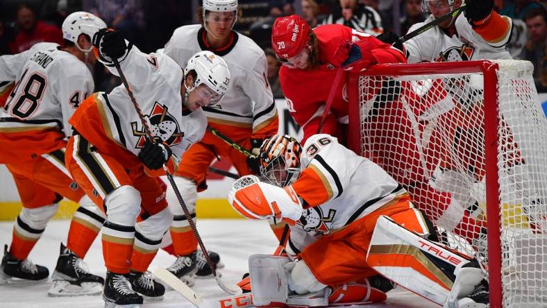 Nov 15, 2022; Anaheim, California, USA; Anaheim Ducks right wing Frank Vatrano (77) helps goaltender John Gibson (36) defend the goal against Detroit Red Wings center Oskar Sundqvist (70) during the first period at Honda Center. Mandatory Credit: Gary A. Vasquez-USA TODAY Sports