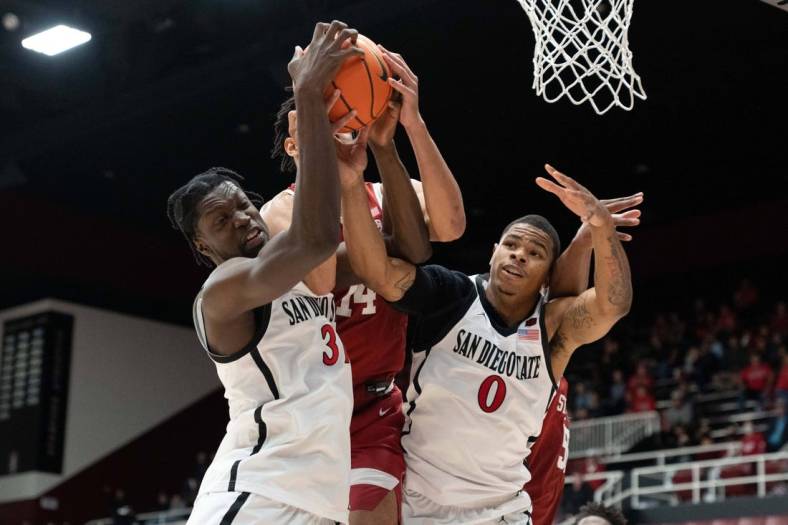 Nov 15, 2022; Stanford, California, USA; San Diego State Aztecs forwards Nathan Mensah (31) and Keshad Johnson (0) fight for the ball against Stanford Cardinal forward Spencer Jones (14) during the second half at Maples Pavilion. Mandatory Credit: Stan Szeto-USA TODAY Sports
