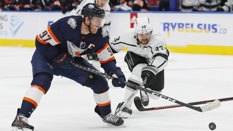 Nov 16, 2022; Edmonton, Alberta, CAN; Los Angeles Kings forward Viktor Arvidsson (33) tries to knock the puck away from Edmonton Oilers forward Connor McDavid (97) during the first period at Rogers Place. Mandatory Credit: Perry Nelson-USA TODAY Sports
