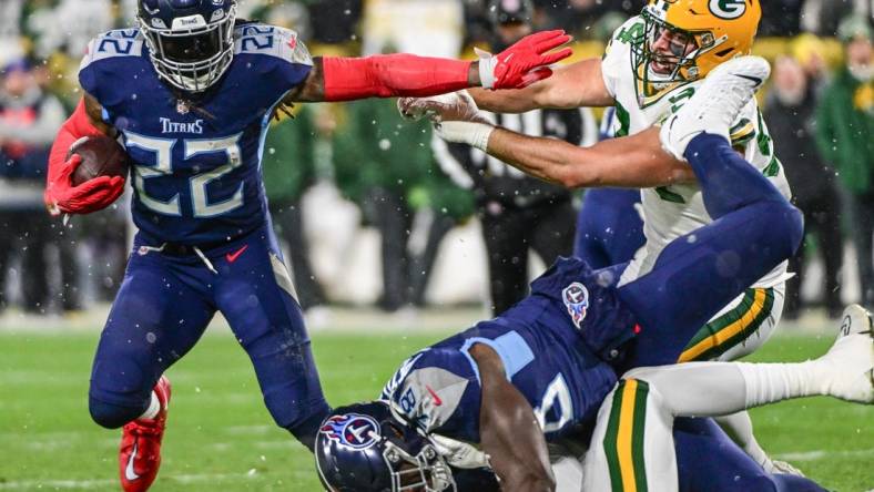 Nov 17, 2022; Green Bay, Wisconsin, USA; Tennessee Titans running back Derrick Henry (22) attempts to break a tackle by Green Bay Packers defensive end Dean Lowry (94) in the first quarter at Lambeau Field. Mandatory Credit: Benny Sieu-USA TODAY Sports