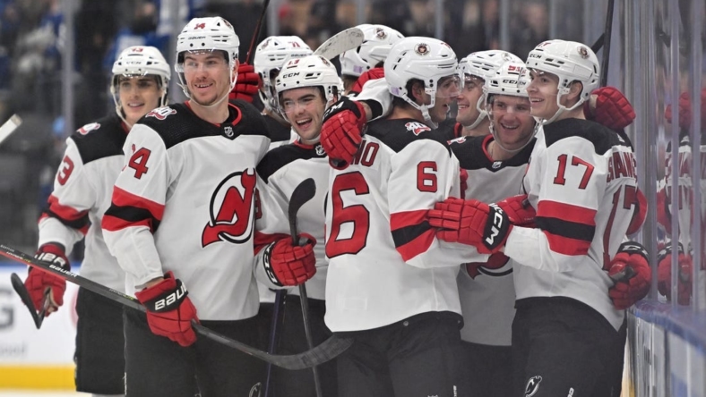 Nov 17, 2022; Toronto, Ontario, CAN; New Jersey Devils forward Yegor Sharangovich (17) celebrates with teammates after scoring a goal in overtime against the Toronto Maple Leafs at Scotiabank Arena. Mandatory Credit: Dan Hamilton-USA TODAY Sports