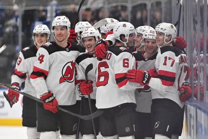 Nov 17, 2022; Toronto, Ontario, CAN; New Jersey Devils forward Yegor Sharangovich (17) celebrates with teammates after scoring a goal in overtime against the Toronto Maple Leafs at Scotiabank Arena. Mandatory Credit: Dan Hamilton-USA TODAY Sports