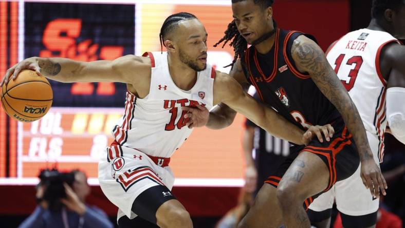 Nov 17, 2022; Salt Lake City, Utah, USA; Utah Utes guard Marco Anthony (10) drives against guard Ronnie Stapp (3) in the fits half at Jon M. Huntsman Center. Mandatory Credit: Jeffrey Swinger-USA TODAY Sports