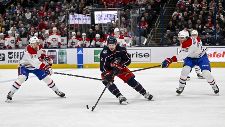 Nov 17, 2022; Columbus, Ohio, USA; Columbus Blue Jackets defenseman Andrew Peeke (2) breaks through Montreal Canadiens right wing Evgenii Dadonov (63) and Montreal Canadiens defenseman Johnathan Kovacevic (26) in the first period at Nationwide Arena. Mandatory Credit: Gaelen Morse-USA TODAY Sports