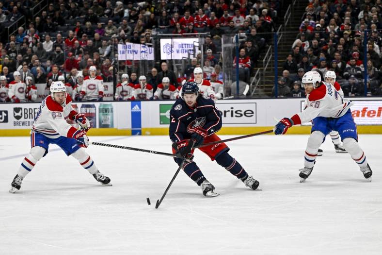 Nov 17, 2022; Columbus, Ohio, USA; Columbus Blue Jackets defenseman Andrew Peeke (2) breaks through Montreal Canadiens right wing Evgenii Dadonov (63) and Montreal Canadiens defenseman Johnathan Kovacevic (26) in the first period at Nationwide Arena. Mandatory Credit: Gaelen Morse-USA TODAY Sports