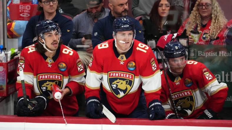 Nov 17, 2022; Sunrise, Florida, USA; Florida Panthers left wing Ryan Lomberg (94), left wing Matthew Tkachuk (19) and center Sam Bennett (9) watch from the bench during the third period against the Dallas Stars at FLA Live Arena. Mandatory Credit: Jasen Vinlove-USA TODAY Sports