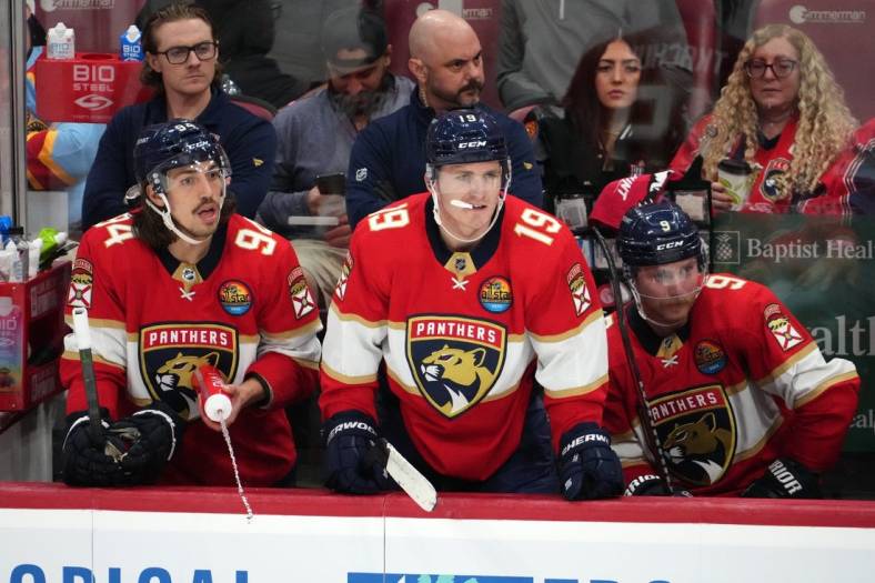 Nov 17, 2022; Sunrise, Florida, USA; Florida Panthers left wing Ryan Lomberg (94), left wing Matthew Tkachuk (19) and center Sam Bennett (9) watch from the bench during the third period against the Dallas Stars at FLA Live Arena. Mandatory Credit: Jasen Vinlove-USA TODAY Sports