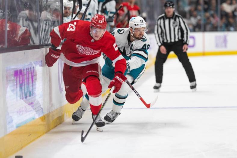 Nov 17, 2022; San Jose, California, USA; Detroit Red Wings left wing Lucas Raymond (23) and San Jose Sharks center Tomas Hertl (48) chase after the puck during the first period at SAP Center at San Jose. Mandatory Credit: Stan Szeto-USA TODAY Sports