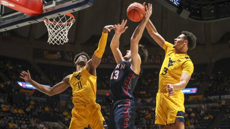 Nov 18, 2022; Morgantown, West Virginia, USA; West Virginia Mountaineers forward Tre Mitchell (3) blocks a shot from Pennsylvania Quakers forward Nick Spinoso (13) during the first half at WVU Coliseum. Mandatory Credit: Ben Queen-USA TODAY Sports