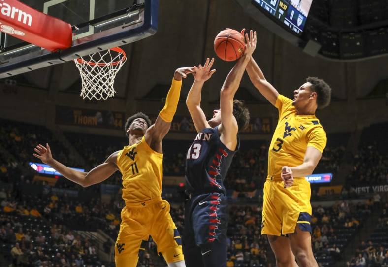 Nov 18, 2022; Morgantown, West Virginia, USA; West Virginia Mountaineers forward Tre Mitchell (3) blocks a shot from Pennsylvania Quakers forward Nick Spinoso (13) during the first half at WVU Coliseum. Mandatory Credit: Ben Queen-USA TODAY Sports