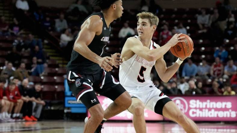 Nov 18, 2022; Charleston, South Carolina, USA; Davidson Wildcats guard Grant Huffman (5) drives around South Carolina Gamecocks guard Jacobi Wright (1) in the first half at TD Arena. Mandatory Credit: David Yeazell-USA TODAY Sports