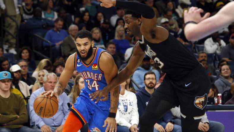 Nov 18, 2022; Memphis, Tennessee, USA; Oklahoma City Thunder forward Kenrich Williams (34) drives to the basket as Memphis Grizzlies forward Jaren Jackson Jr. (13) defends during the second quarter at FedExForum. Mandatory Credit: Petre Thomas-USA TODAY Sports