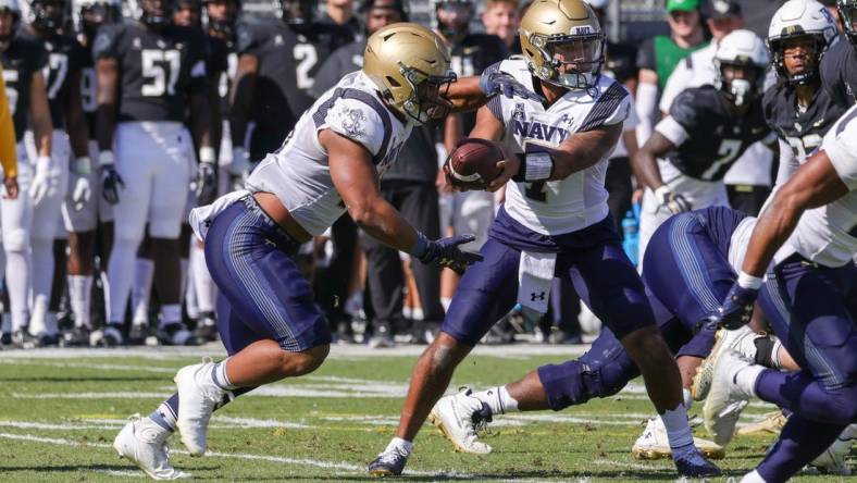 Nov 19, 2022; Orlando, Florida, USA; Navy Midshipmen quarterback Xavier Arline (7) hands off to Navy Midshipmen fullback Daba Fofana (45) during the first quarter at FBC Mortgage Stadium. Mandatory Credit: Mike Watters-USA TODAY Sports