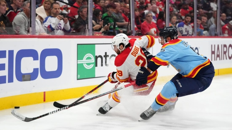 Nov 19, 2022; Sunrise, Florida, USA; Florida Panthers defenseman Aaron Ekblad (5) and Calgary Flames center Dillon Dube (29) battle for a loose puck during the first period at FLA Live Arena. Mandatory Credit: Jasen Vinlove-USA TODAY Sports