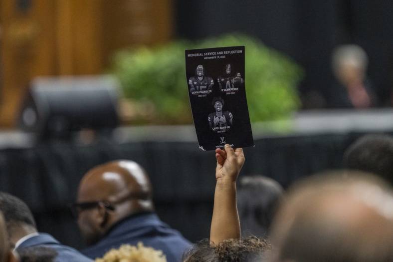 Nov 19, 2022; Charlottesville, Virginia, US; A flyer is held up during the memorial service for three slain University of Virginia football players Lavel Davis Jr., D Sean Perry and Devin Chandler at John Paul Jones Arena. Mandatory Credit: Erin Edgerton/Pool Photo-USA TODAY Sports