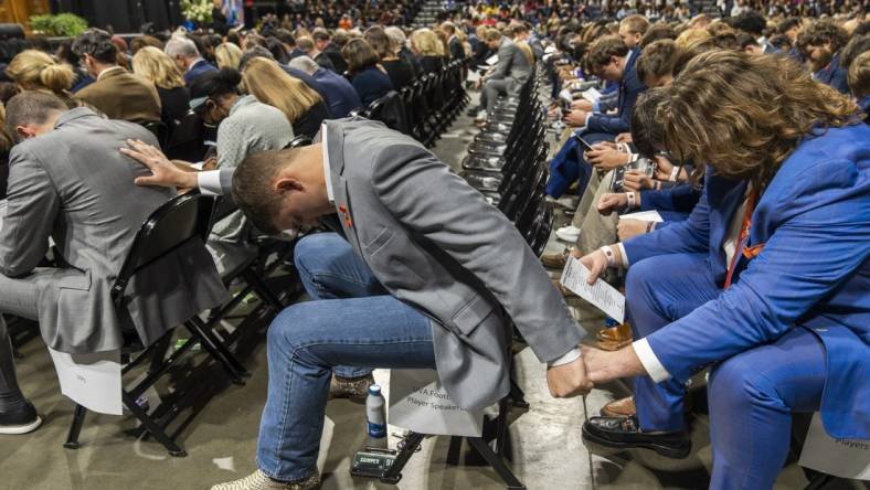 Nov 19, 2022; Charlottesville, Virginia, US; A general view as members of the Virginia Cavaliers football team pray during the memorial service for three slain University of Virginia football players Lavel Davis Jr., D Sean Perry and Devin Chandler at John Paul Jones Arena. Mandatory Credit: Erin Edgerton/Pool Photo-USA TODAY Sports