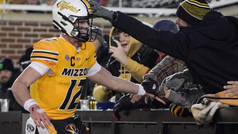 Nov 19, 2022; Columbia, Missouri, USA; Missouri Tigers quarterback Brady Cook (12) celebrates with fans after a score against the New Mexico State Aggies during the second half at Faurot Field at Memorial Stadium. Mandatory Credit: Denny Medley-USA TODAY Sports