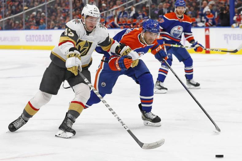 Nov 19, 2022; Edmonton, Alberta, CAN; Vegas Golden Knights forward Paul Cotter (43) and Edmonton Oilers defensemen Evan Bouchard (2) chase a loose pucks during the second period at Rogers Place. Mandatory Credit: Perry Nelson-USA TODAY Sports