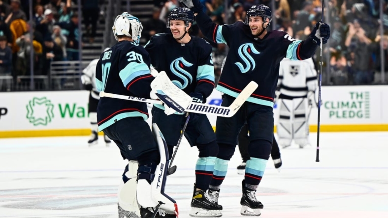 Nov 19, 2022; Seattle, Washington, USA; Seattle Kraken goaltender Martin Jones (30) and defenseman Will Borgen (3) and defenseman Carson Soucy (28) celebrate after defeating the Los Angeles Kings during the first overtime period at Climate Pledge Arena. Seattle won 3-2. Mandatory Credit: Steven Bisig-USA TODAY Sports