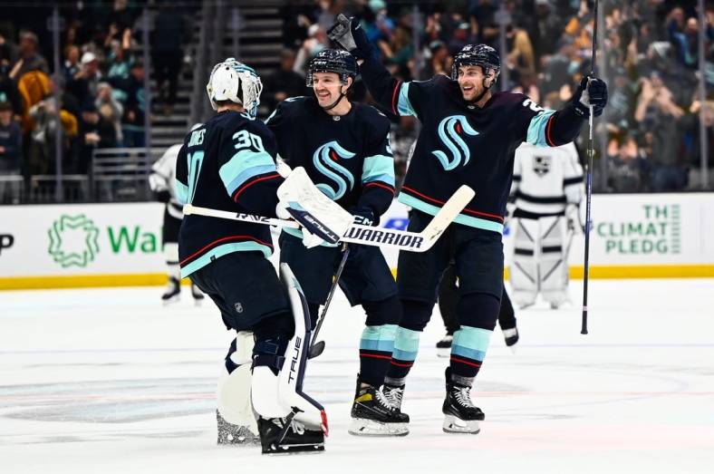 Nov 19, 2022; Seattle, Washington, USA; Seattle Kraken goaltender Martin Jones (30) and defenseman Will Borgen (3) and defenseman Carson Soucy (28) celebrate after defeating the Los Angeles Kings during the first overtime period at Climate Pledge Arena. Seattle won 3-2. Mandatory Credit: Steven Bisig-USA TODAY Sports