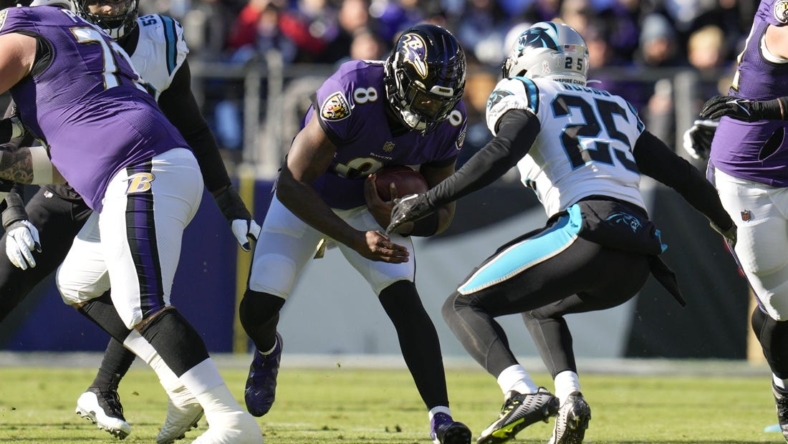 Nov 20, 2022; Baltimore, Maryland, USA;  Baltimore Ravens quarterback Lamar Jackson (8) runs with the ball against Carolina Panthers safety Xavier Woods (25) for a first down during the first half at M&T Bank Stadium. Mandatory Credit: Jessica Rapfogel-USA TODAY Sports