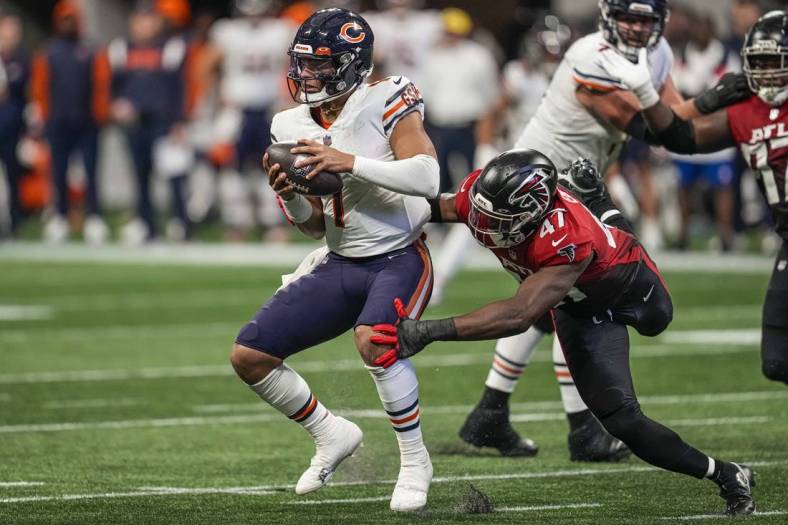 Nov 20, 2022; Atlanta, Georgia, USA; Chicago Bears quarterback Justin Fields (1) tries to evade a tackle by Atlanta Falcons defensive end Arnold Ebiketie (47) during the second half at Mercedes-Benz Stadium. Mandatory Credit: Dale Zanine-USA TODAY Sports
