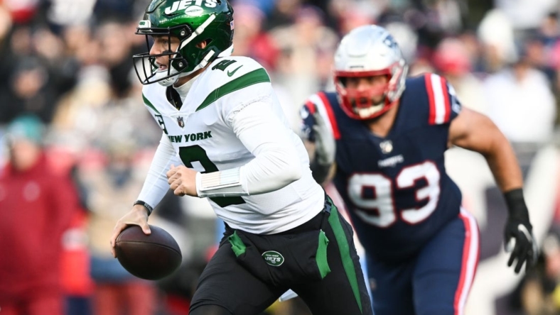 Nov 20, 2022; Foxborough, Massachusetts, USA; New York Jets quarterback Zach Wilson (2) runs under pressure from New England Patriots defensive end Lawrence Guy (93) during the first half at Gillette Stadium. Mandatory Credit: Brian Fluharty-USA TODAY Sports