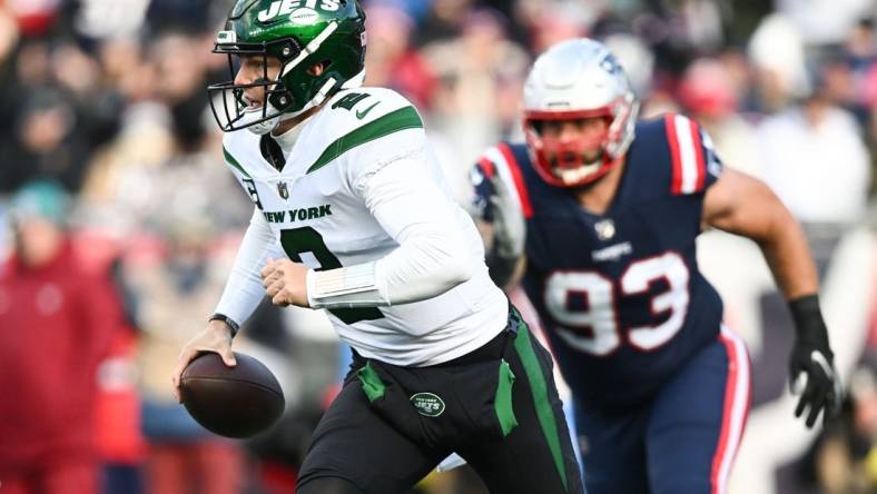 Nov 20, 2022; Foxborough, Massachusetts, USA; New York Jets quarterback Zach Wilson (2) runs under pressure from New England Patriots defensive end Lawrence Guy (93) during the first half at Gillette Stadium. Mandatory Credit: Brian Fluharty-USA TODAY Sports