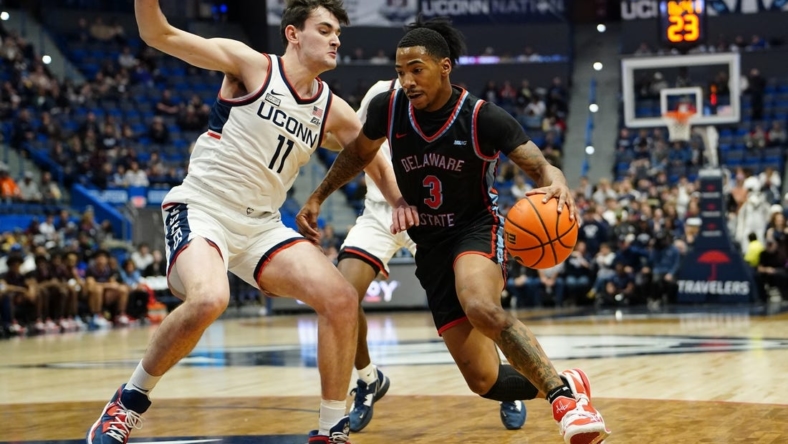 Nov 20, 2022; Hartford, Connecticut, USA; Delaware State Hornets guard Martaz Robinson (3) dribbles the ball against Connecticut Huskies forward Alex Karaban (11) during the first half  at XL Center. Mandatory Credit: Gregory Fisher-USA TODAY Sports