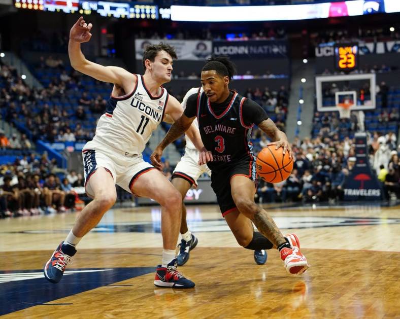 Nov 20, 2022; Hartford, Connecticut, USA; Delaware State Hornets guard Martaz Robinson (3) dribbles the ball against Connecticut Huskies forward Alex Karaban (11) during the first half  at XL Center. Mandatory Credit: Gregory Fisher-USA TODAY Sports