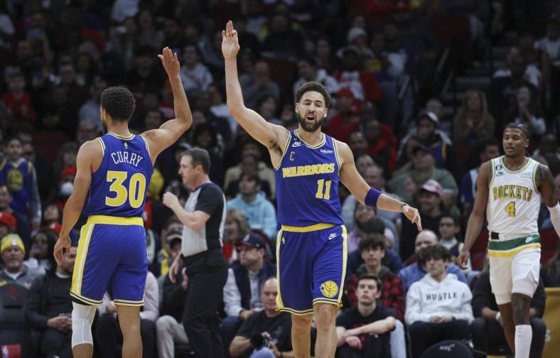 Nov 20, 2022; Houston, Texas, USA; Golden State Warriors guard Klay Thompson (11) and guard Stephen Curry (30) celebrate after a play during the first quarter against the Houston Rockets at Toyota Center. Mandatory Credit: Troy Taormina-USA TODAY Sports