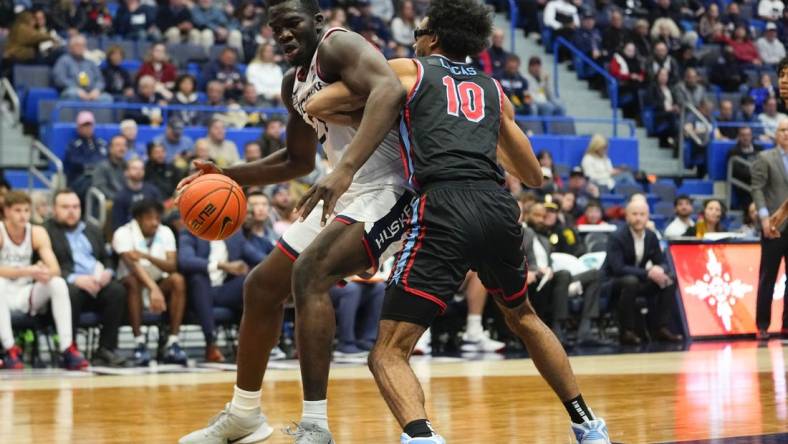 Nov 20, 2022; Hartford, Connecticut, USA; Connecticut Huskies forward Adama Sanogo (21) dribbles the ball against Delaware State Hornets forward Ronald Lucas (10) during the second half at XL Center. Mandatory Credit: Gregory Fisher-USA TODAY Sports