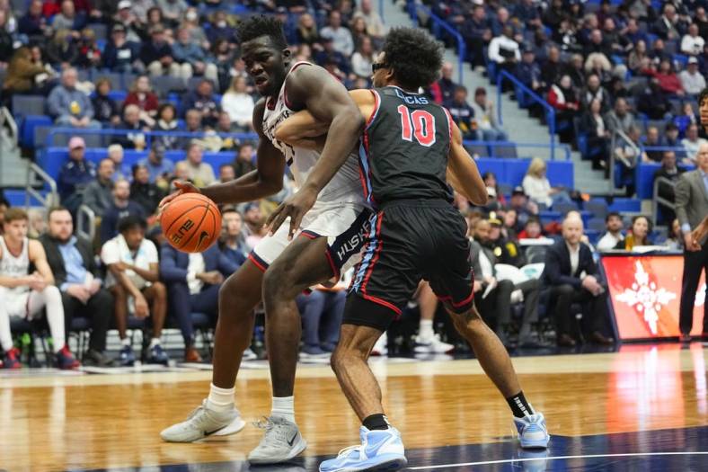 Nov 20, 2022; Hartford, Connecticut, USA; Connecticut Huskies forward Adama Sanogo (21) dribbles the ball against Delaware State Hornets forward Ronald Lucas (10) during the second half at XL Center. Mandatory Credit: Gregory Fisher-USA TODAY Sports