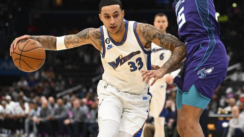 Nov 20, 2022; Washington, District of Columbia, USA; Washington Wizards forward Kyle Kuzma (33) dribbles as Charlotte Hornets forward P.J. Washington (25) defends during the first half at Capital One Arena. Mandatory Credit: Brad Mills-USA TODAY Sports