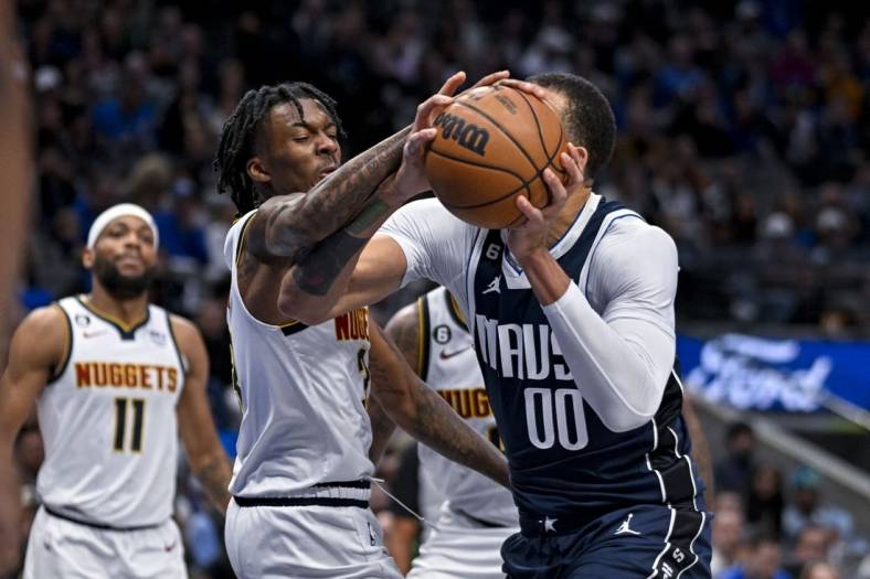 Nov 20, 2022; Dallas, Texas, USA; Dallas Mavericks center JaVale McGee (00) is fouled by Denver Nuggets guard Bones Hyland (3) during the second quarter at the American Airlines Center. Mandatory Credit: Jerome Miron-USA TODAY Sports