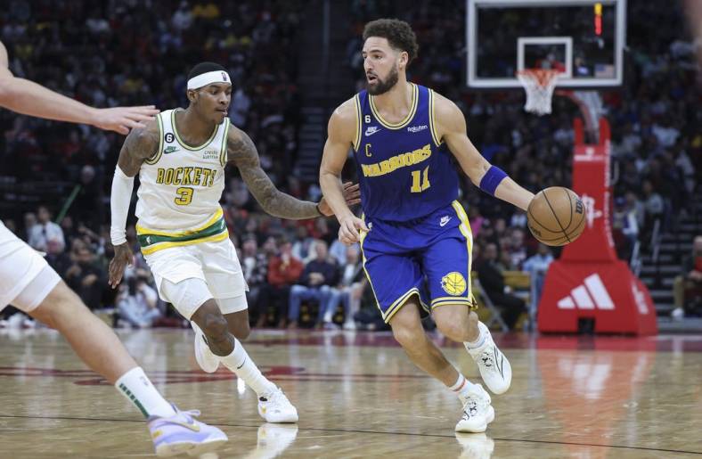 Nov 20, 2022; Houston, Texas, USA; Golden State Warriors guard Klay Thompson (11) dribbles the ball as Houston Rockets guard Kevin Porter Jr. (3) defends during the fourth quarter at Toyota Center. Mandatory Credit: Troy Taormina-USA TODAY Sports