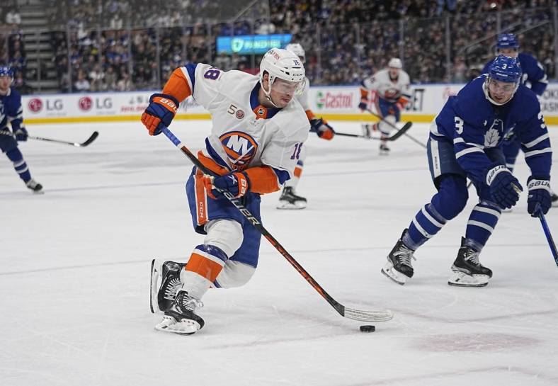 Nov 21, 2022; Toronto, Ontario, CAN; New York Islanders forward Anthony Beauvillier (18) carries the puck as Toronto Maple Leafs defenseman Justin Holl (3) defends during the second period at Scotiabank Arena. Mandatory Credit: John E. Sokolowski-USA TODAY Sports
